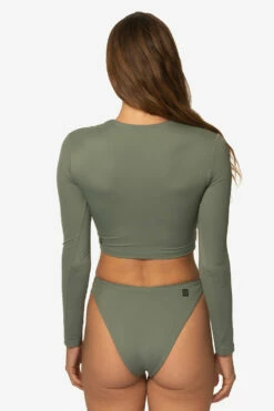 Taranaki Long Sleeved Crop Cut-Out Rashie - Eucalyptus 18 Taranaki Long Sleeved Crop Cut-Out Rashie - Eucalyptus -JOLYN Sales Swim Tops Taranaki Solid Eucalyptus Back TiaSurf MiskaSykora 021023