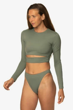 Taranaki Long Sleeved Crop Cut-Out Rashie - Eucalyptus 21 Taranaki Long Sleeved Crop Cut-Out Rashie - Eucalyptus -JOLYN Sales Swim Tops Taranaki Solid Eucalyptus Front Side TiaSurf MiskaSykora 021023